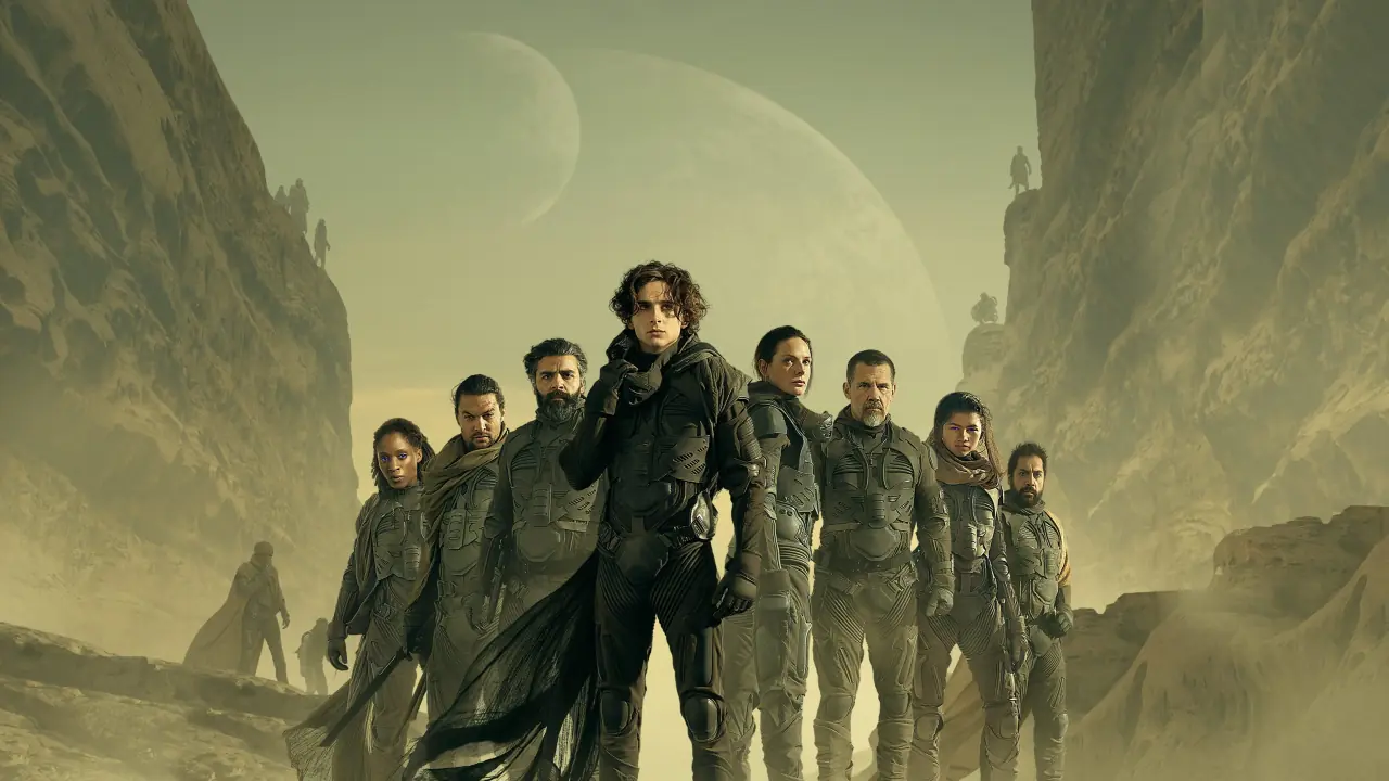 A visually stunning promotional image from the 2021 sci-fi film "Dune: Part One," produced by Warner Bros., showcasing the protagonist, Paul Atreides, in a vast desert landscape with colossal sand dunes and a massive sandworm, highlighting the film's epic scale, intricate world-building, and themes of destiny and survival.