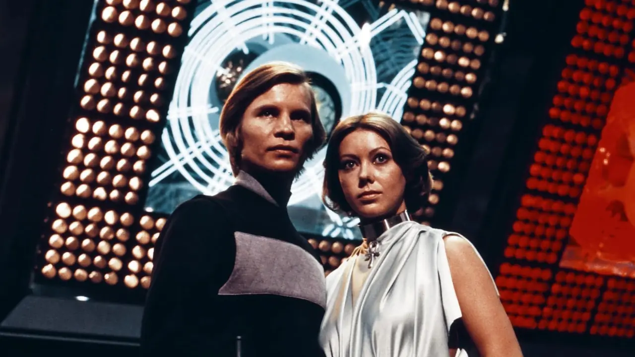 "A scene from the science fiction film 'Logan's Run' (1976), produced by Metro-Goldwyn-Mayer (MGM). The image shows a futuristic cityscape with vibrant colors, featuring young people in stylish attire, reflecting the film's themes of youth and a dystopian society that mandates life termination at age 30.